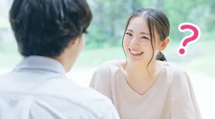 笑顔の女性が向い合った男性と会話しているシーン